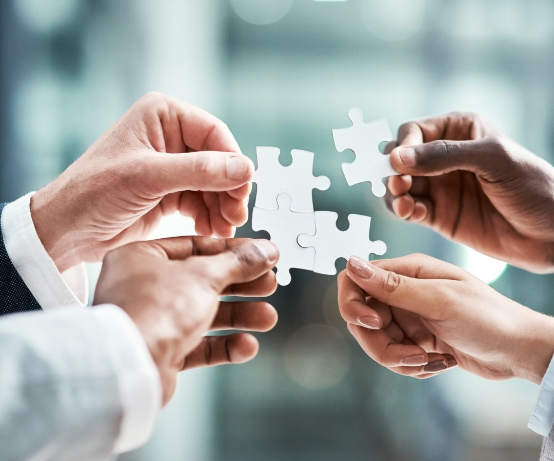 Hands holding puzzle pieces symbolizing teamwork and collaboration